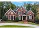 Brick house with black shutters, a large front yard, and a circular driveway at 2214 Taylor Grady Ter, Duluth, GA 30097