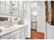 White wet bar with glass-front cabinets and a sink at 2214 Taylor Grady Ter, Duluth, GA 30097