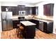 Kitchen with island, stainless steel appliances, and dark cabinets at 2338 Newbury Oaks Dr, Lawrenceville, GA 30044