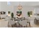 Dining room with large windows, a round table, and a modern chandelier at 351 Willowwind Dr, Loganville, GA 30052