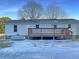 Rear view of house showcasing deck and snowy yard at 574 Pool Rd, Hiram, GA 30141