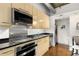 Sleek kitchen with stainless steel appliances and light wood cabinetry at 123 Luckie Nw St # 2210, Atlanta, GA 30303