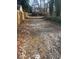 Long gravel driveway lined with wooden fences and overgrown trees on either side at 2025 Moody Sw Dr, Atlanta, GA 30315