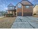 Brick two-story house with a three-car garage and landscaping at 8372 Members Dr, Jonesboro, GA 30236