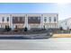 Three modern townhouses with white siding, dark brown accents, and private fenced patios at 896 Farmstead Rd, Suwanee, GA 30024