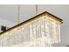 A close up shot of a rectangular chandelier with glass rods and a gold chain at 2795 Peachtree Rd # 1305, Atlanta, GA 30305