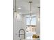 Modern kitchen lighting fixtures hang over a stone countertop and stainless steel kitchen faucet at 2795 Peachtree Rd # 1305, Atlanta, GA 30305
