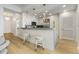 A bright, modern kitchen features white cabinets, a breakfast bar, and modern pendant lights at 2795 Peachtree Rd # 1305, Atlanta, GA 30305