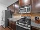 Modern kitchen with stainless steel appliances and dark brown cabinets at 1227 Clear Stream Rdg, Auburn, GA 30011