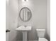 Modern powder room with pedestal sink, decorative mirror, and a toilet at 6935 Melody Dr, Buford, GA 30518