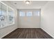 Well-lit bedroom features dark laminate flooring, light walls, and large windows with views of the neighborhood at 6935 Melody Dr, Buford, GA 30518