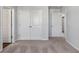 Bedroom with plush carpet and several closet and bathroom door entrances at 6935 Melody Dr, Buford, GA 30518