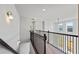 Hallway with metal railing overlooking the living room and large windows providing natural light at 6935 Melody Dr, Buford, GA 30518