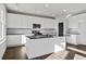 Well-lit kitchen with white cabinetry, stainless steel appliances, dark countertops and an island with sink at 6935 Melody Dr, Buford, GA 30518