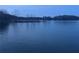 Scenic view of a calm lake at twilight, surrounded by trees with a rocky shore at 6935 Melody Dr, Buford, GA 30518