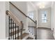 Elegant staircase with wood and iron railing leading to the upper level, with view of the front door at 6935 Melody Dr, Buford, GA 30518