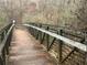 Rustic wooden bridge with weathered railings surrounded by trees at 6935 Melody Dr, Buford, GA 30518