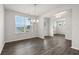 Elegant dining room with laminate flooring, modern chandelier, and large sunlit window at 6935 Melody Ridge Rd, Buford, GA 30518