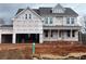 New construction home featuring a two-car garage and covered front porch at 6935 Melody Ridge Rd, Buford, GA 30518