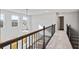 Bright hallway with wood railing, carpet flooring, and windows allowing natural light at 6935 Melody Ridge Rd, Buford, GA 30518