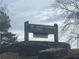 A sign for Lower Pool West Park is surrounded by rocky landscaping and bare trees, suggesting a natural and peaceful environment at 6935 Melody Ridge Rd, Buford, GA 30518