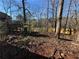 Wooded backyard with a partially visible deck and wooden fence at 5449 Martins Crossing Rd, Stone Mountain, GA 30088