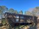 Brick home with wooden deck and surrounding trees at 10650 Panhandle Rd, Hampton, GA 30228