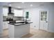 Modern kitchen with white cabinets, black countertops, and a breakfast bar at 1807 W Austin Rd, Decatur, GA 30032