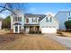 Two-story house with a two-car garage and landscaped lawn at 7124 Big Woods Dr, Woodstock, GA 30189