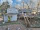 The back exterior showcases a charming two-story home with a deck and stairs nestled among mature trees at 2545 Kingswood Dr, Marietta, GA 30066