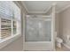 Bathroom with shower/tub combo with sliding glass door, tile floors, and a window at 2545 Kingswood Dr, Marietta, GA 30066