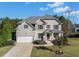 Two-story house with a three-car garage and manicured lawn at 308 Evening Rain Crst, Canton, GA 30114