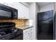 Updated kitchen featuring black appliances, granite countertops, and tile backsplash at 557 Summit Sw Ln, Marietta, GA 30008