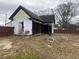 View of the home's dilapidated rear and unkempt backyard at 7163 Swift St, Lithonia, GA 30058