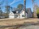 White farmhouse exterior with gray roof, two-car garage, and landscaped yard at 4392 Navajo Se Ln, Acworth, GA 30102