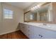 Bathroom with double vanity, wood framed mirror, and flooring at 910 Callee Dr, Loganville, GA 30052