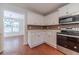 White kitchen cabinets, stainless steel appliances, and hardwood floors at 910 Callee Dr, Loganville, GA 30052