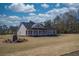 Inviting exterior featuring a long porch and neutral colors, creating a warm and welcoming atmosphere at 85 Woodfin Way, Social Circle, GA 30025