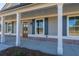 Close up of the home's inviting front porch featuring white columns and a beautiful wood door at 85 Woodfin Way, Social Circle, GA 30025