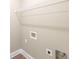 Neutral colored laundry room with wooden floors, trim, and wire shelving at 85 Woodfin Way, Social Circle, GA 30025