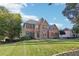 Brick two-story house with a well-manicured lawn and mature trees at 4385 Chatuge Dr, Buford, GA 30519