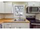 Modern kitchen with white cabinets, butcher block counters, and stainless steel appliances at 2178 Baker Nw Ter, Atlanta, GA 30318