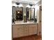 Bathroom with dual sinks, granite countertops, large mirrors, and modern lighting at 747 Dogwood Cir, Norcross, GA 30071
