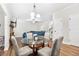 Bright dining area with glass table and four chairs, hardwood floors, and adjacent living room at 2647 Old Snapping Shoals Rd, Mcdonough, GA 30252