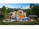 Stunning evening view of the home's rear exterior, showcasing the pool, spa, waterfall, fire pit, and outdoor kitchen at 5330 Lake Redwine Nw Cv, Acworth, GA 30101