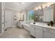 Bright bathroom featuring dual vanities, a freestanding tub, and a view from the window with plantation shutters at 5330 Lake Redwine Nw Cv, Acworth, GA 30101