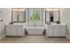 Elegant bathroom featuring a soaking tub between dual vanities, with a window view and stylish tile flooring at 5330 Lake Redwine Nw Cv, Acworth, GA 30101