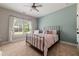 Bedroom with carpet flooring, a ceiling fan, and a large window for bright natural light at 5330 Lake Redwine Nw Cv, Acworth, GA 30101