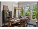 Elegant dining room featuring a rustic wood table, sophisticated chandelier, and bright natural light from large windows at 5330 Lake Redwine Nw Cv, Acworth, GA 30101