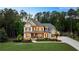 Beautiful home featuring a lush green lawn, colorful flowerbeds, and a basketball hoop on the driveway at 5330 Lake Redwine Nw Cv, Acworth, GA 30101